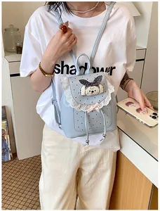 Light blue mini backpack with lace trim and cute cartoon dog patch worn by model