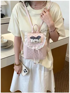 Detail shot of a sweet pink mini backpack with white lace trim and cute cartoon dog patch