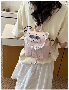 Detail view of pink mini backpack with lace trim and puppy decoration on a model