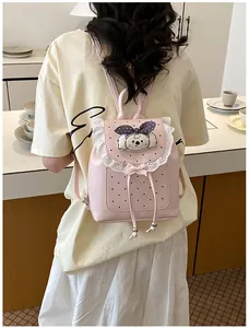 Sweet pink mini backpack featuring delicate lace trim and cute plush dog charm on model