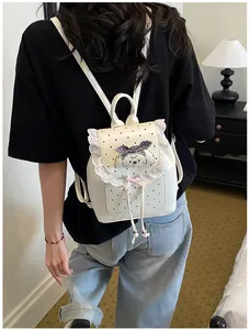 A sweet white mini backpack with delicate lace trim and a cute puppy detail worn by a model.