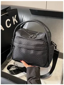Close-up of black nylon checkered handbag with front zipper pocket and wide strap