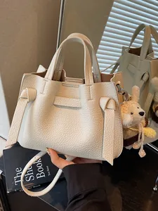 Sac cabas élégant en cuir grainé crème pour les trajets professionnels.