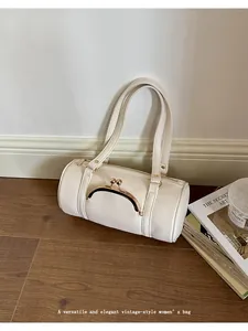 Elegant cream pebbled leather barrel bag with vintage kiss-lock detail and shoulder straps