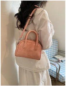 Pink mini crossbody pillow bag styled over the shoulder for a trendy lifestyle look.