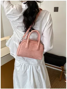 Back view detail of a pink suede pillow handbag styled with a white summer dress