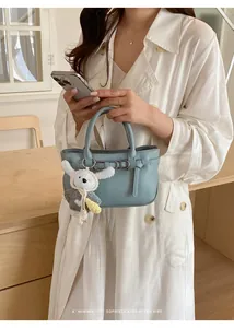 Vista dettagliata di una borsa minimalista azzurra con un grazioso ciondolo a coniglio