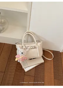 Elegante borsa tote in pelle crema con ciondolo a coniglio e tracolla staccabile