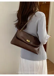 Back view of a woman wearing a dark brown quilted chain shoulder bag in a retro style