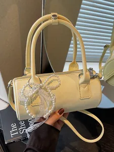 Elegant cream barrel handbag with decorative pearl bow and lace detail for women's fashion