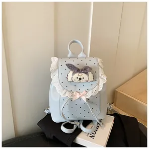 Close-up of sweet light blue mini backpack featuring elegant lace trim and a cute dog patch