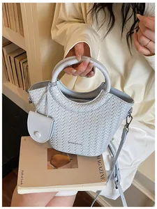 Detailed view of a stylish light blue woven bucket bag for casual commute fashion.