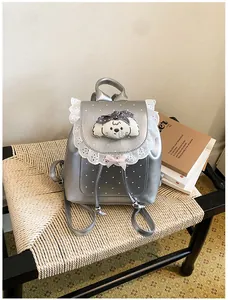 Close-up of sweet silver mini backpack with white lace trim and cute dog patch.
