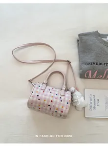 Elegante bolso de barril con lunares rosas y un lindo llavero de conejo blanco
