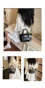 Chic black textured bucket bag with metallic lock and puppy charm detail