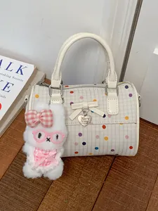 Elegante bolso Boston crema con lunares y un tierno amuleto de conejo de peluche