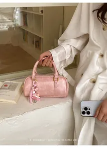 Detailed view of trendy pink textured pillow handbag with a decorative charm
