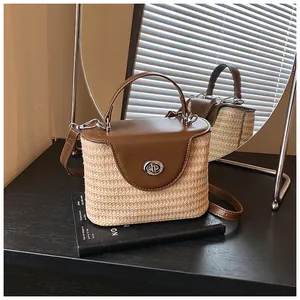 Vue détaillée d'un sac seau en paille tissée avec rabat en cuir marron et fermoir