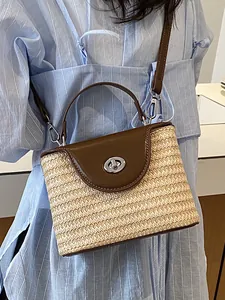 Sac seau en paille tressée avec rabat en cuir marron et fermoir tournant argenté
