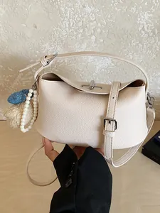 Borsa a mano in pelle martellata bianco crema con fibbia argento e ciondolo di perle.