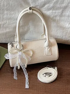 Elegant white cylindrical bolster bag with a delicate pearl lace bow charm for women