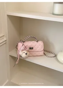 Elegant pink quilted mini square handbag featuring a cute fluffy bear keychain detail