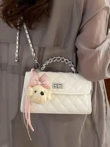 Elegant white quilted crossbody bag with silver chain handle and a cute teddy bear charm