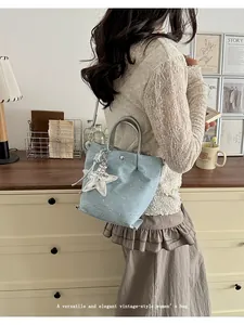 Stylish light blue denim crossbody bag with sparkling rhinestones and star charm detail