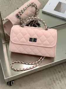 Stylish pink quilted small square handbag with silver metallic chain strap and turn-lock.