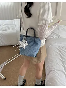 Vintage style blue denim crossbody dumpling bag for women featuring a large star charm