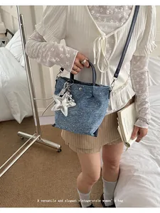 Elegant lifestyle view of a vintage denim tote bag with a metallic star charm