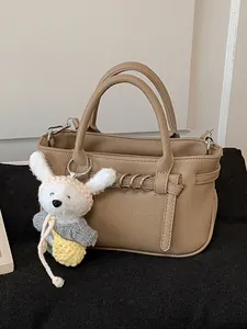 Elegante borsa a mano kaki con un simpatico ciondolo a forma di coniglietto