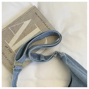 Close-up of durable denim fabric and adjustable shoulder strap on a blue crossbody bag
