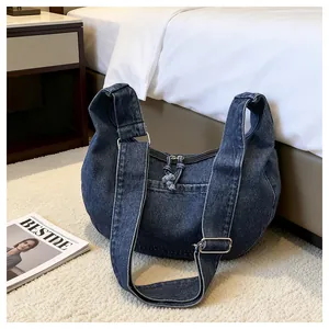 Detail view of large denim crossbody hobo bag with adjustable wide shoulder strap