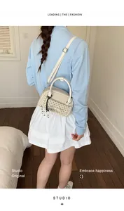 Sac à bandoulière beige à pois noirs porté par un mannequin en tenue décontractée
