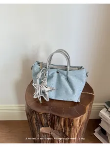 Light blue denim handbag with silver star charm and elegant rhinestone studs