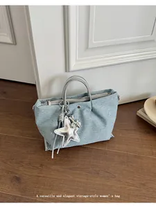 Versatile light blue denim handbag featuring a silver star charm in a lifestyle setting