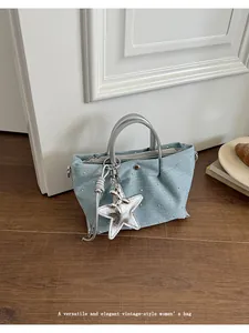 Elegant light blue denim handbag with rhinestones and star charm in lifestyle scene