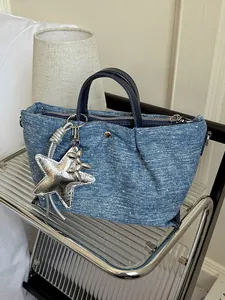 Stylish blue denim dumpling handbag featuring a silver star charm for chic casual commuting