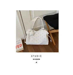 Stylish white large capacity polka-dot tote bag with star charm in a lifestyle setting.