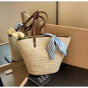 Vue détaillée d'un grand sac de plage en paille tressée avec un foulard rayé bleu chic