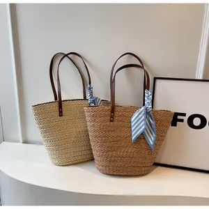 Détail de sacs fourre-tout en paille tressée à la main en crème et marron décorés