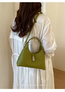 Detailed view of a green woven bucket bag worn by a model in a white coat.