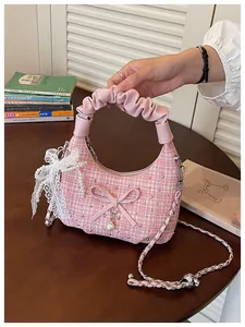 Vue détaillée d'un sac à main en tweed rose avec poignée plissée et détails en dentelle