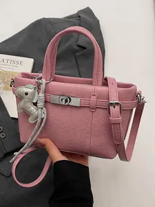 Pink textured leather handbag with dog charm for women's office commuting style