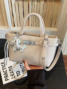 Elegant beige textured handbag with horse charm for professional commuting and daily use