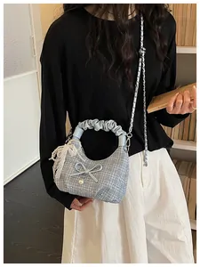 Vue détaillée du sac à main en tweed bleu avec nœud et poignée froncée élégante