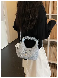 Vue arrière d'un mannequin portant un sac demi-lune en tweed bleu clair plissé.