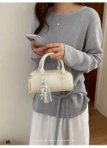 Retro cream white pillow bag held by model with minimalist sophisticated vibe