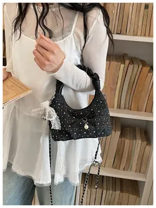 Vue détaillée d'un sac hobo en tweed noir avec perles, nœud et ruban de dentelle